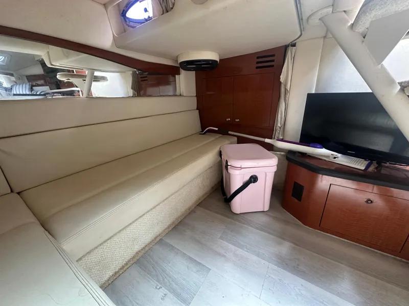 Slide: The Image of Interior of 2004 Sea Ray 340 Sundancer with beige seating, TV, and cooler. - 33