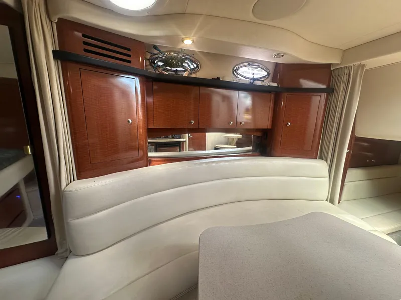 Slide: The Image of 2004 Sea Ray 340 Sundancer interior with curved seating and wooden cabinetry. - 37