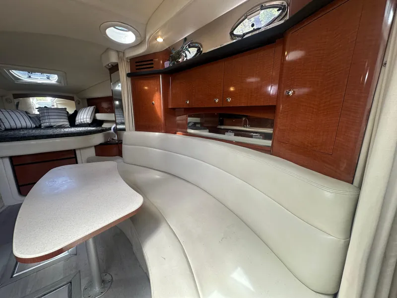 Slide: The Image of 2004 Sea Ray 340 Sundancer interior with curved seating and wooden cabinetry. - 38