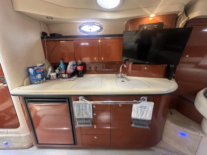 Slide: The Image of 2004 Sea Ray 340 Sundancer yacht interior with kitchenette, sink, and mounted TV. - 39