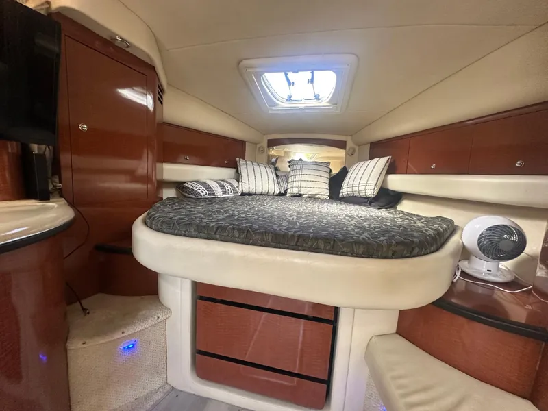 Slide: The Image of 2004 Sea Ray 340 Sundancer cabin interior with bed, wood cabinets, and ceiling hatch. - 41