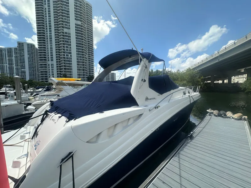 Slide: The Image of 2004 Sea Ray 340 Sundancer docked near high-rise buildings under a clear blue sky. - 6