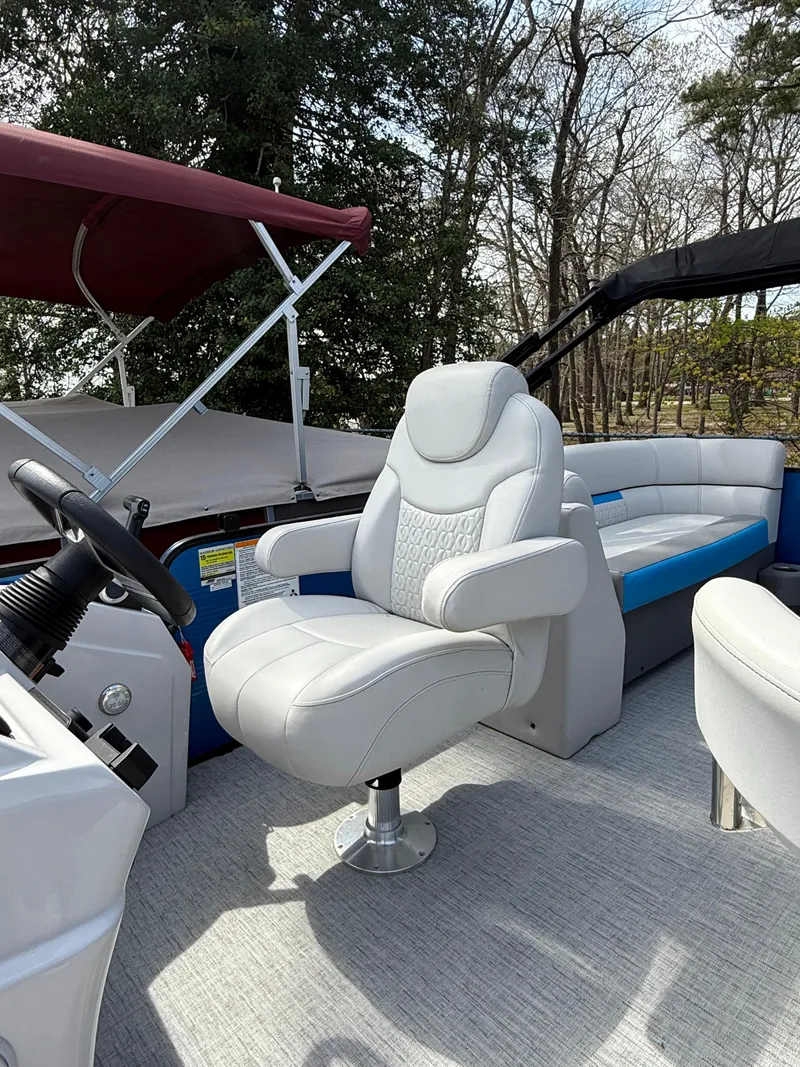 Slide: The Image of 2021 Godfrey SWEETWATER 2286 MT boat interior with plush seating and steering console. - 10