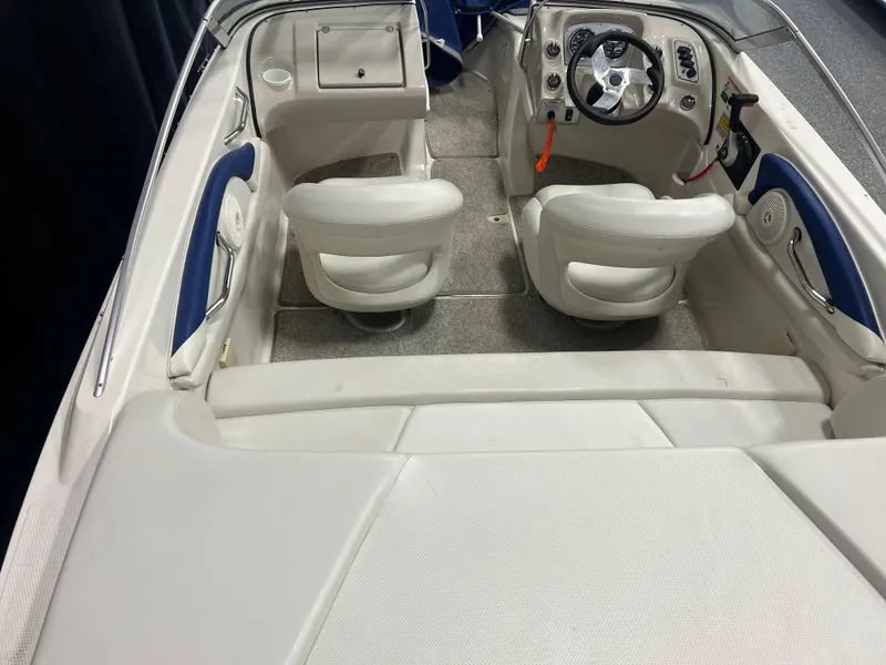 Slide: The Image of 2007 Larson 180 Sport boat interior with white seating and steering console. - 14