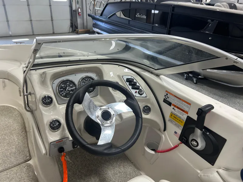 Slide: The Image of 2007 Larson 180 Sport boat dashboard with steering wheel and controls in a showroom. - 9