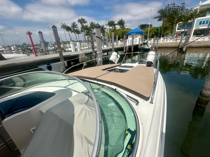 Slide: The Image of 2012 Sea Ray 310 Sundancer docked at marina with palm trees and clear sky. - 14
