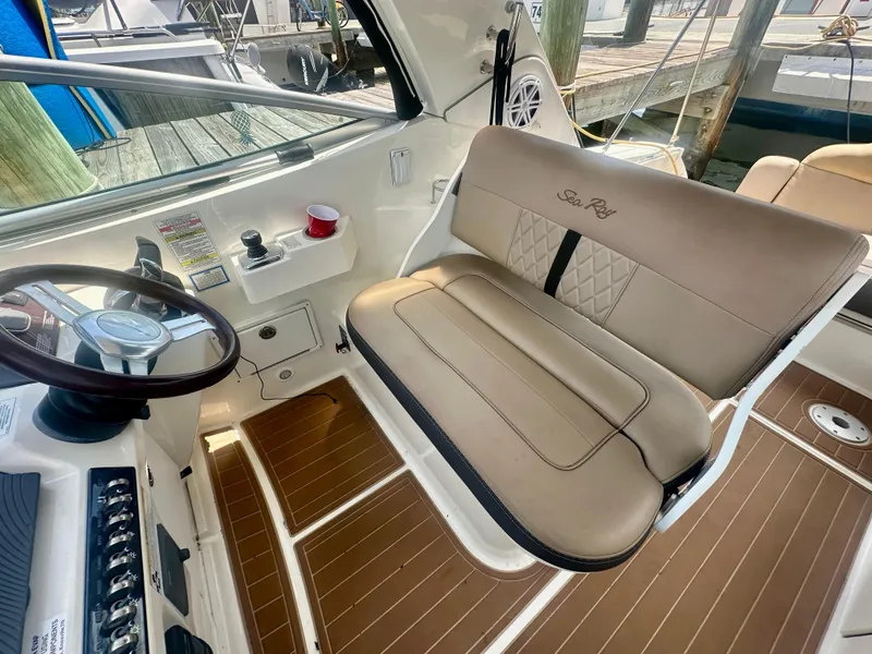 Slide: The Image of 2012 Sea Ray 310 Sundancer helm with tan seating and wood accents. - 15