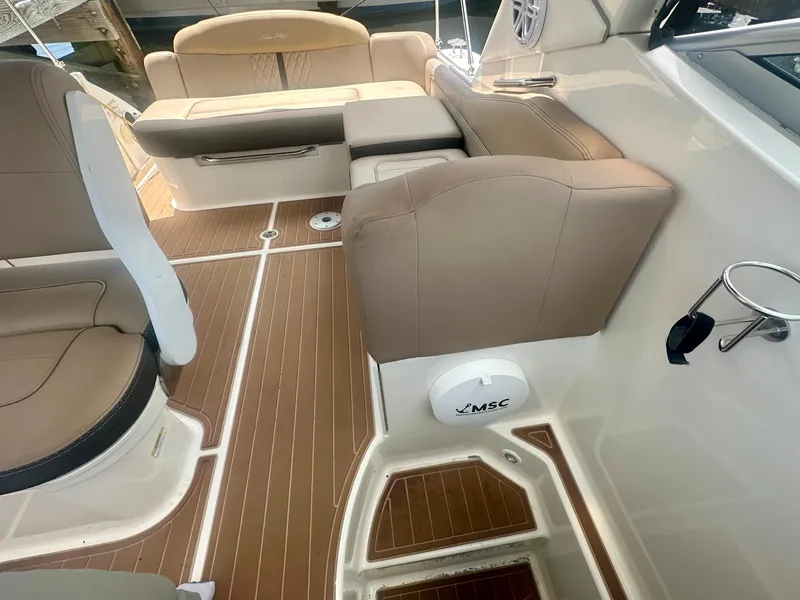 Slide: The Image of Interior view of 2012 Sea Ray 310 Sundancer boat with tan seating and wood flooring. - 27
