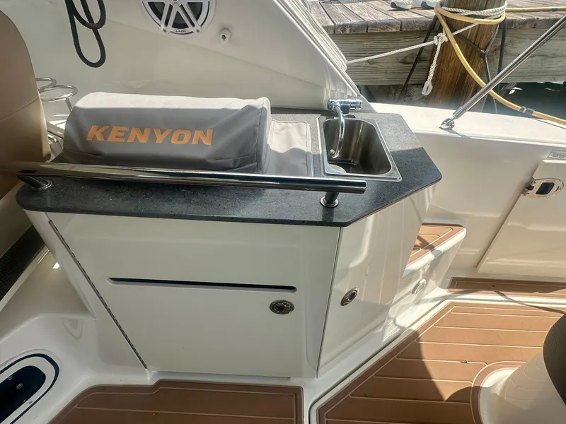 Slide: The Image of Outdoor kitchenette on 2012 Sea Ray 310 Sundancer boat with Kenyon grill. - 29