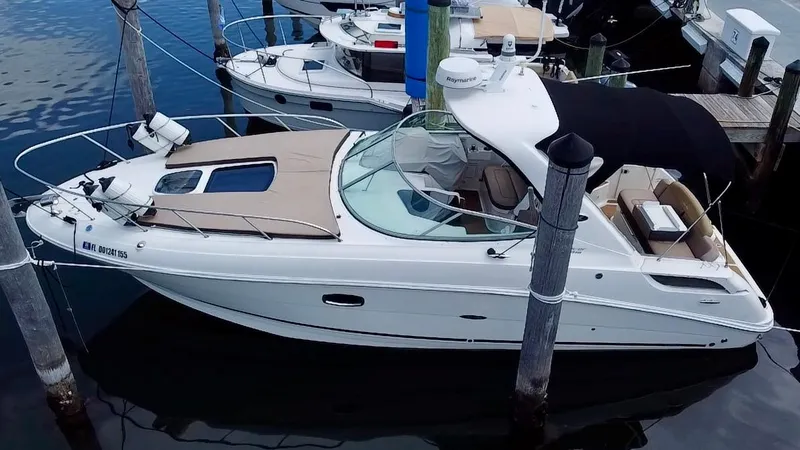 Slide: The Image of 2012 Sea Ray 310 Sundancer boat docked at marina, featuring sleek design and spacious deck. - 3