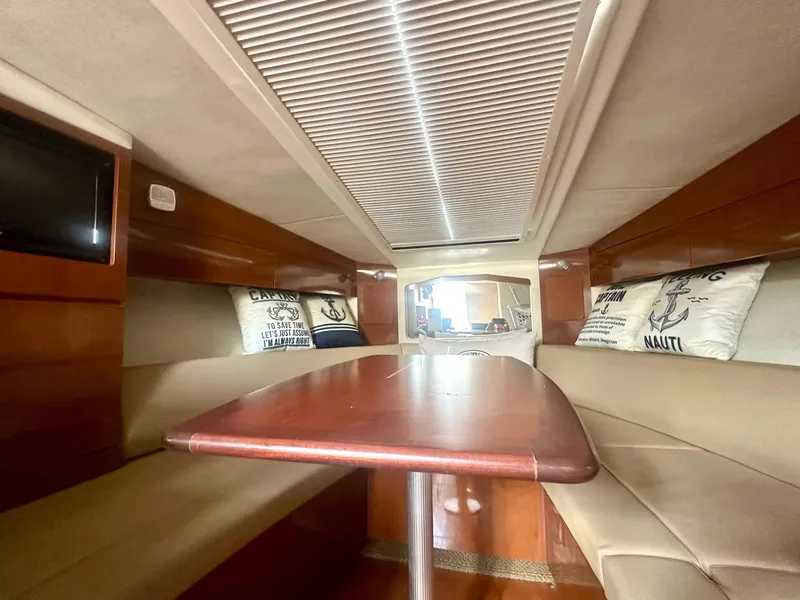 Slide: The Image of Interior of 2012 Sea Ray 310 Sundancer with cozy seating and wooden table. - 37
