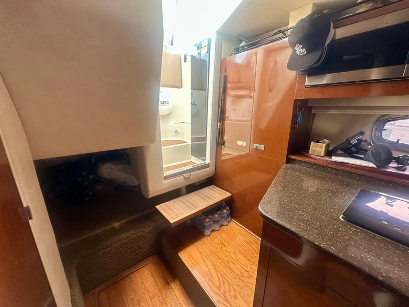 Slide: The Image of Interior of 2012 Sea Ray 310 Sundancer yacht, featuring wood finishes and compact design. - 41