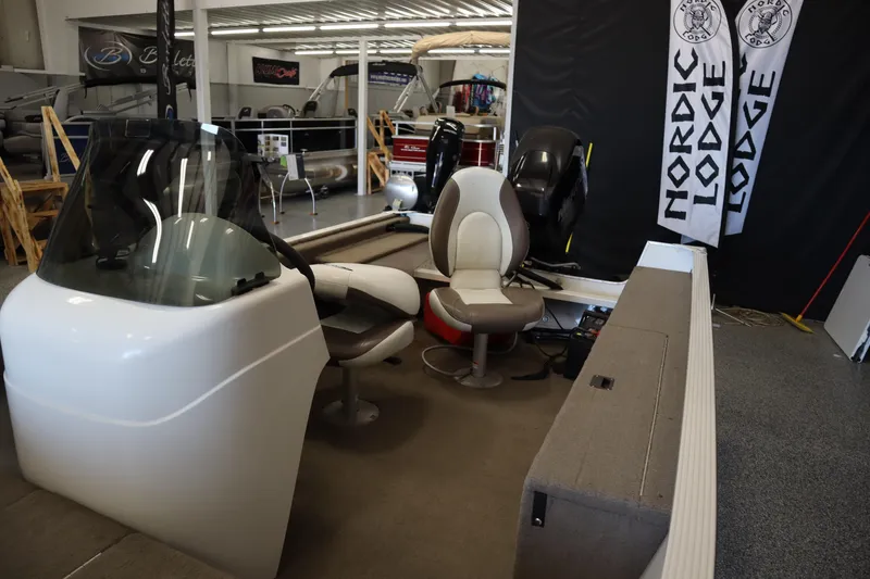 Slide: The Image of 2013 MirroCraft 1416 Troller boat interior with seating and console in showroom. - 19