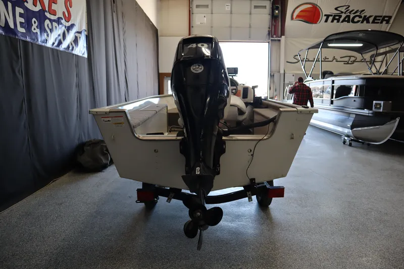 Slide: The Image of 2013 MirroCraft 1416 Troller boat in showroom, rear view with outboard motor. - 5