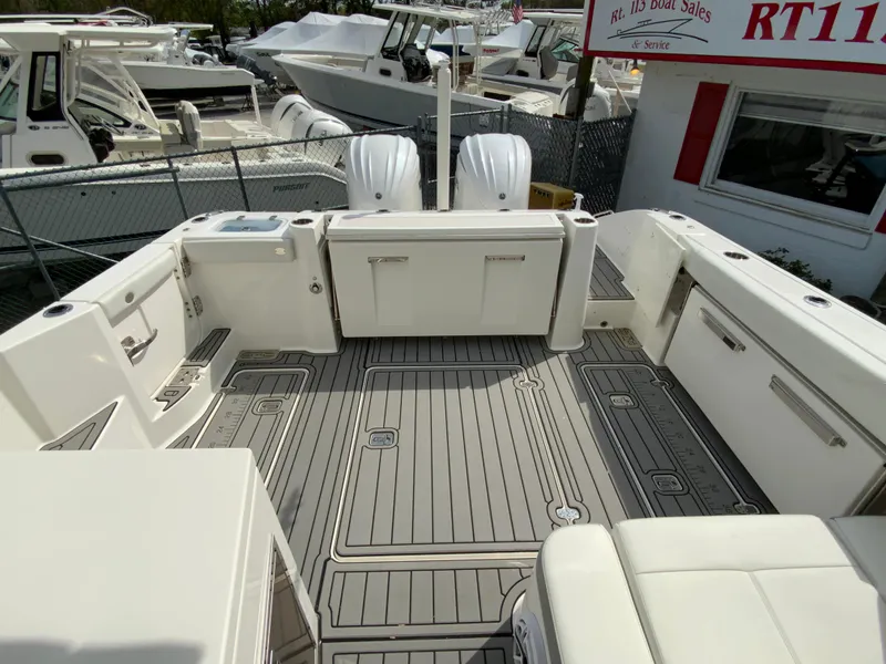 Slide: The Image of 2023 Pursuit DC 326 Dual Console boat interior with spacious deck and seating. - 11
