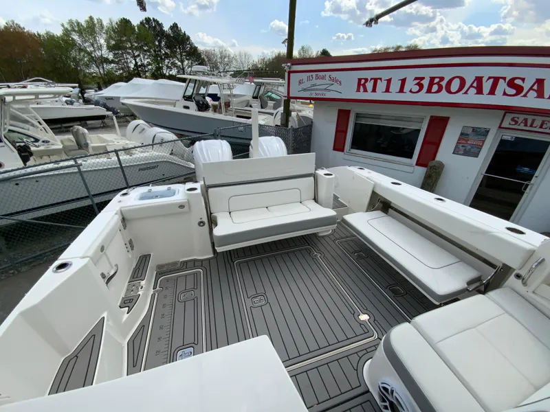 Slide: The Image of 2023 Pursuit DC 326 Dual Console boat at dealership, featuring spacious seating and modern design. - 13