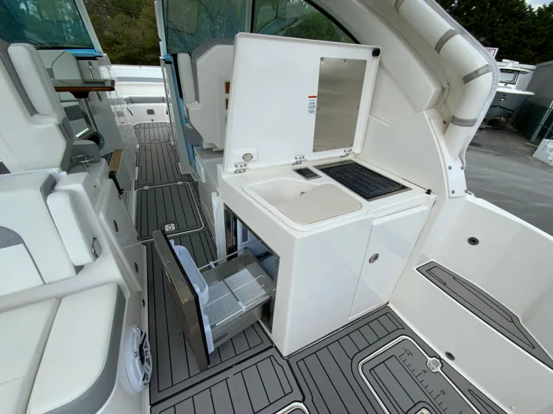 Slide: The Image of 2023 Pursuit DC 326 Dual Console boat interior with kitchenette and storage. - 15