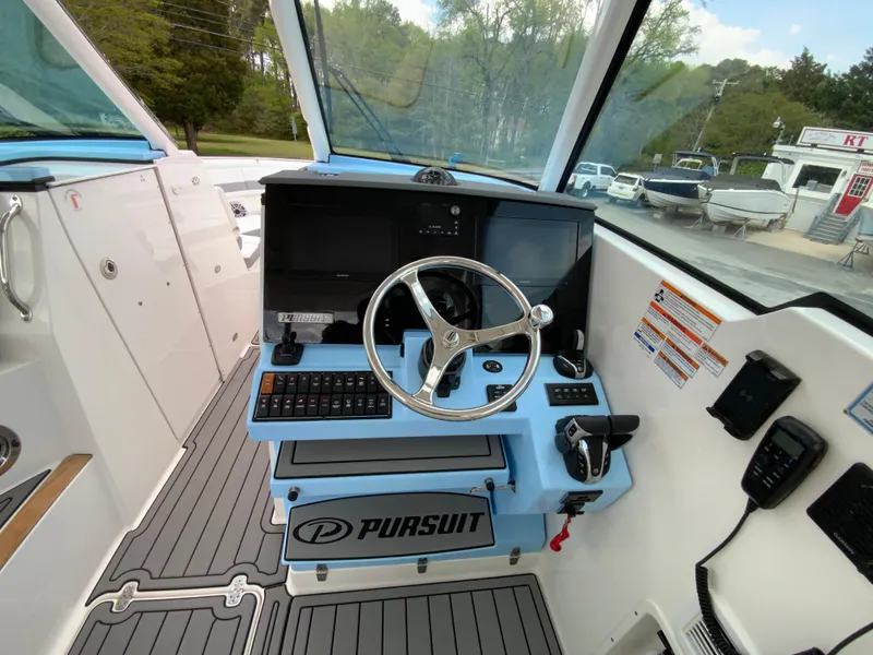 Slide: The Image of 2023 Pursuit DC 326 Dual Console boat cockpit with steering wheel and control panel. - 17