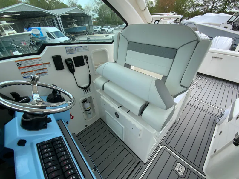 Slide: The Image of 2023 Pursuit DC 326 Dual Console boat interior with helm, seating, and modern controls. - 18