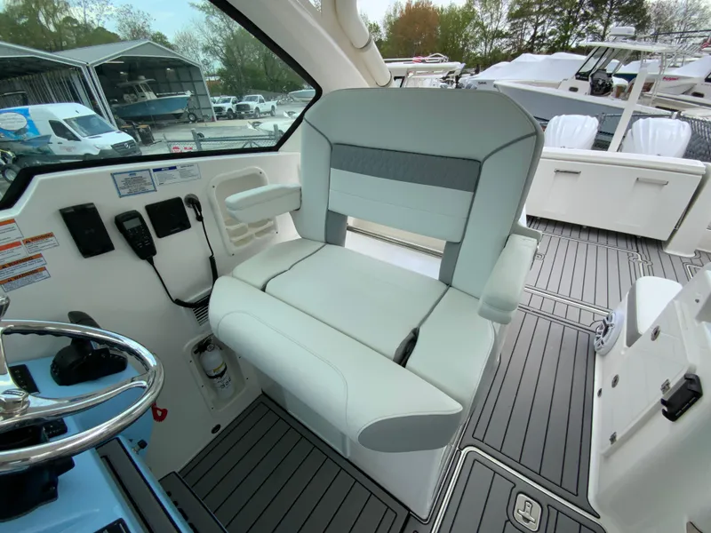 Slide: The Image of 2023 Pursuit DC 326 Dual Console boat interior with sleek seating and modern controls. - 19