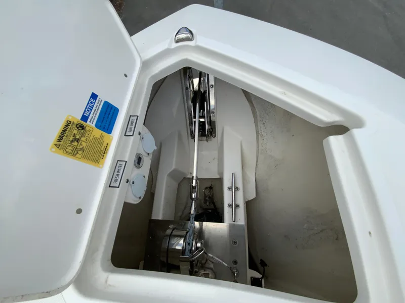 Slide: The Image of 2023 Pursuit DC 326 Dual Console anchor compartment with visible winch and chain mechanism. - 25