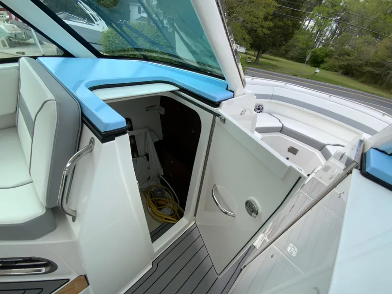 Slide: The Image of 2023 Pursuit DC 326 Dual Console boat interior with open storage compartment. - 28