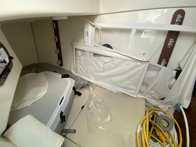 Slide: The Image of 2023 Pursuit DC 326 Dual Console interior storage area with equipment and cables. - 29