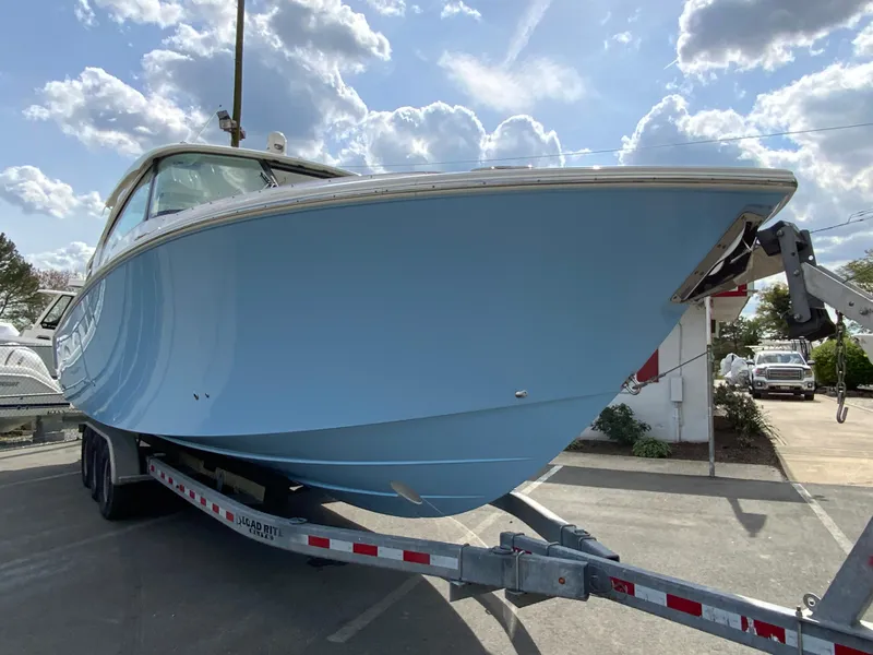 Slide: The Image of 2023 Pursuit DC 326 Dual Console boat on trailer under cloudy sky. - 3