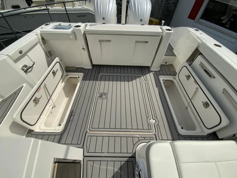 Slide: The Image of 2023 Pursuit DC 326 Dual Console boat deck with storage compartments and sleek design. - 32