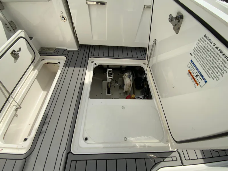 Slide: The Image of 2023 Pursuit DC 326 Dual Console boat storage compartments and deck view. - 33