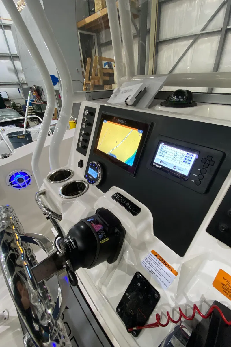 Slide: The Image of 2022 Robalo R200 Center Console boat dashboard with navigation screens and controls. - 12