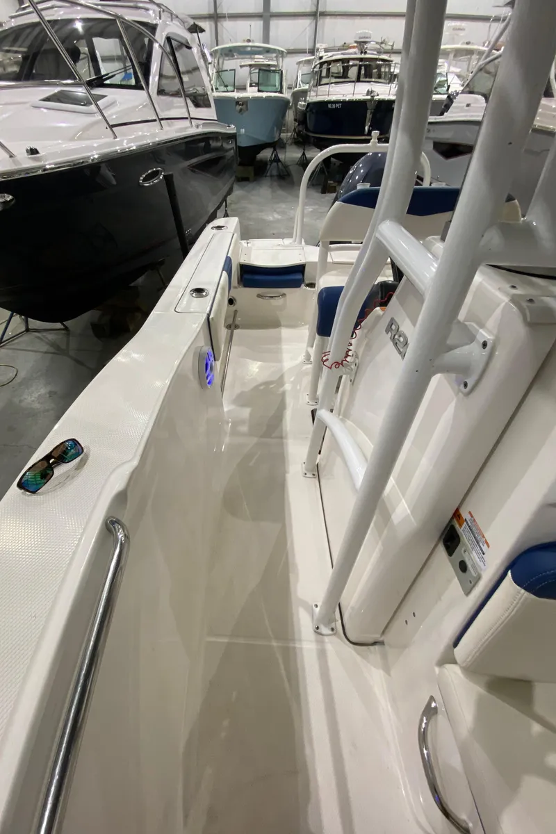 Slide: The Image of 2022 Robalo R200 Center Console boat interior in showroom, featuring sleek design and modern amenities. - 16