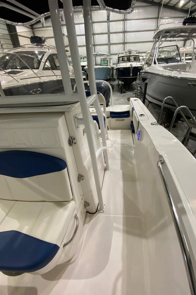 Slide: The Image of 2022 Robalo R200 Center Console boat interior with blue and white seating in a showroom. - 17