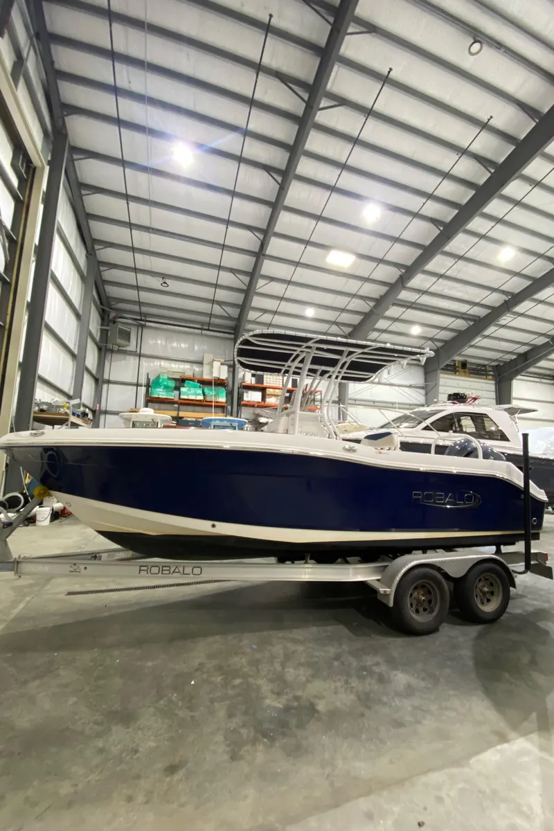 Slide: The Image of 2022 Robalo R200 Center Console boat in a storage facility on a trailer. - 2
