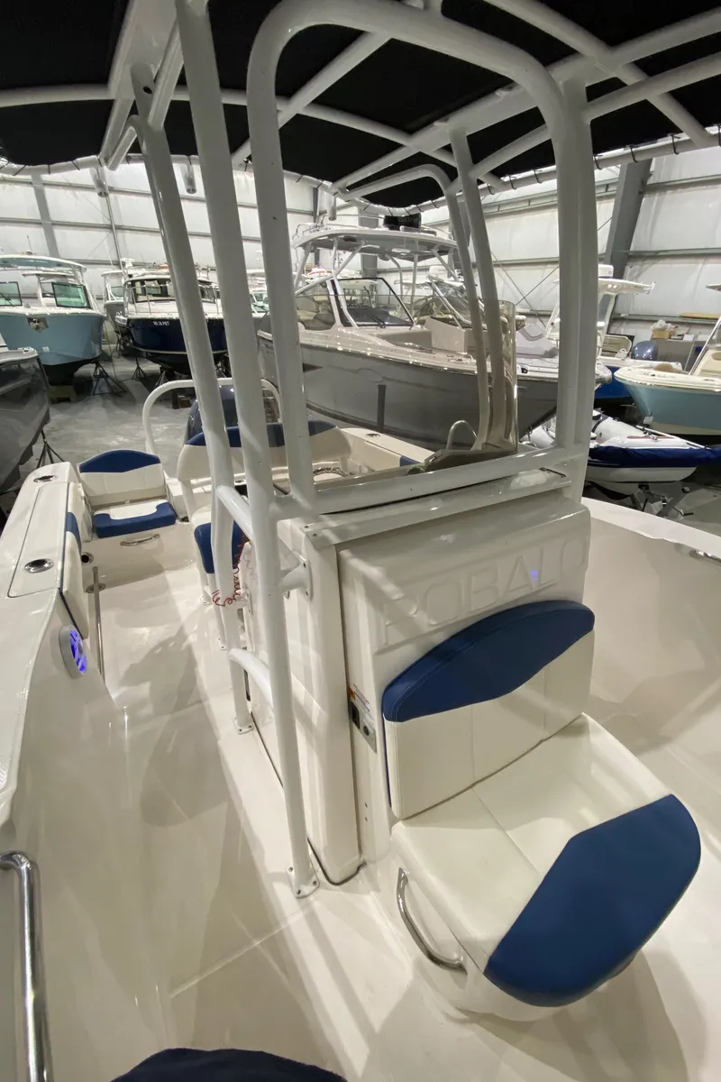 Slide: The Image of 2022 Robalo R200 Center Console boat with blue seating, displayed in a showroom. - 21