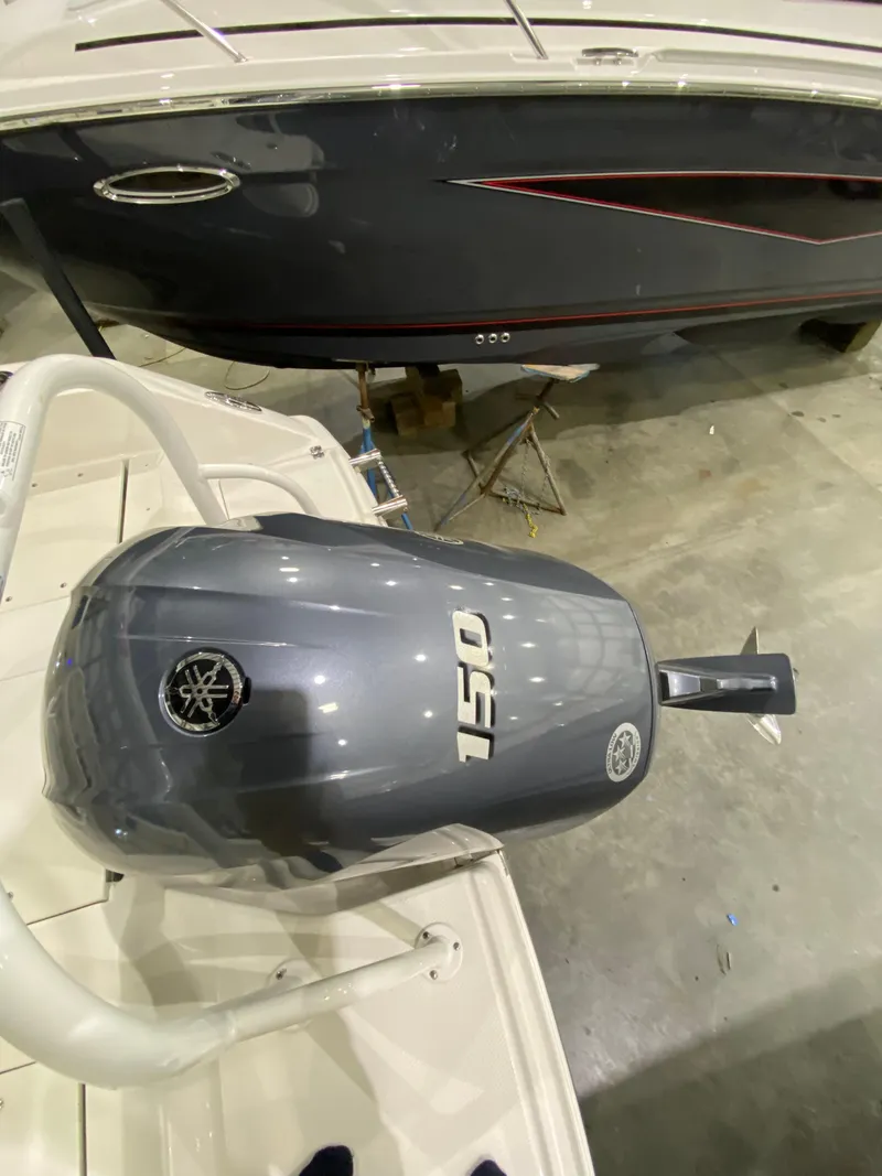 Slide: The Image of 2022 Robalo R200 Center Console with Yamaha 150 outboard engine in a showroom. - 22
