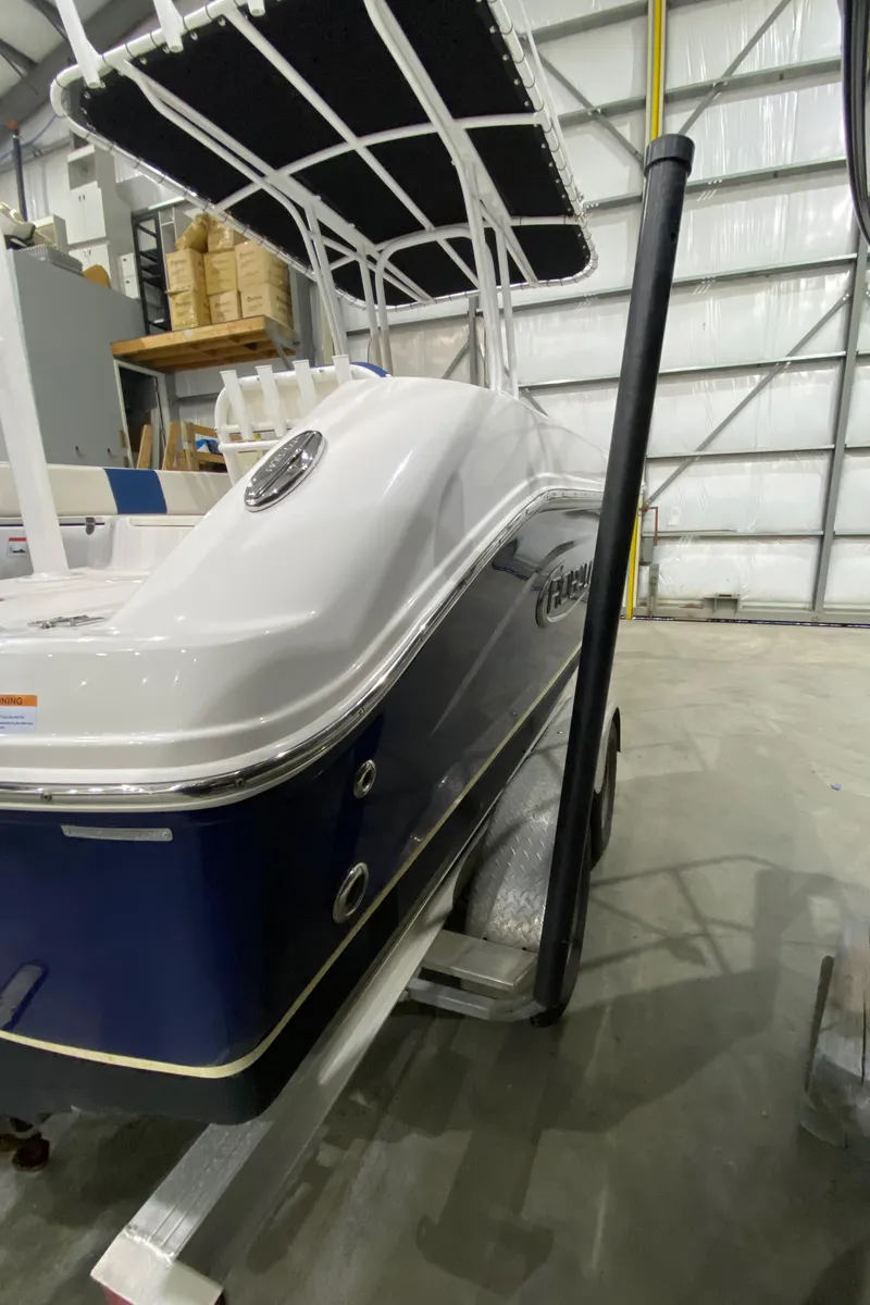 Slide: The Image of 2022 Robalo R200 Center Console boat in storage, featuring sleek design and blue hull. - 7