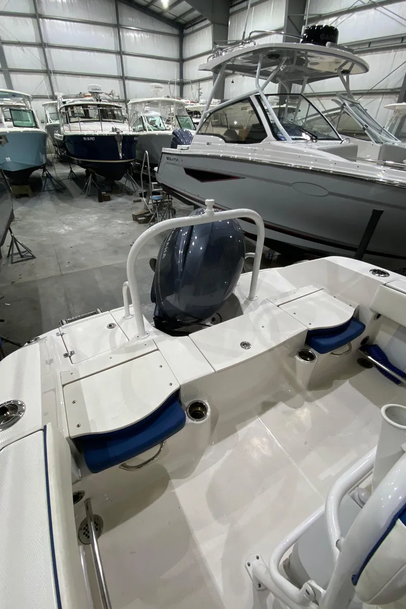 Slide: The Image of 2022 Robalo R200 Center Console boat in a showroom with other vessels. - 9