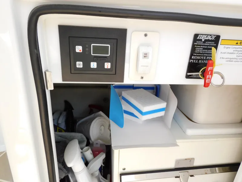 Slide: The Image of Control panel and storage area on a 2015 Formula YACHT 45, featuring cleaning supplies and fire safety equipment. - 48