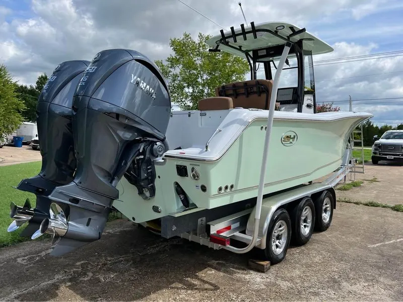 Slide: The Image of 2022 Sea Hunt Gamefish 27 boat with dual Yamaha engines on a trailer. - 1