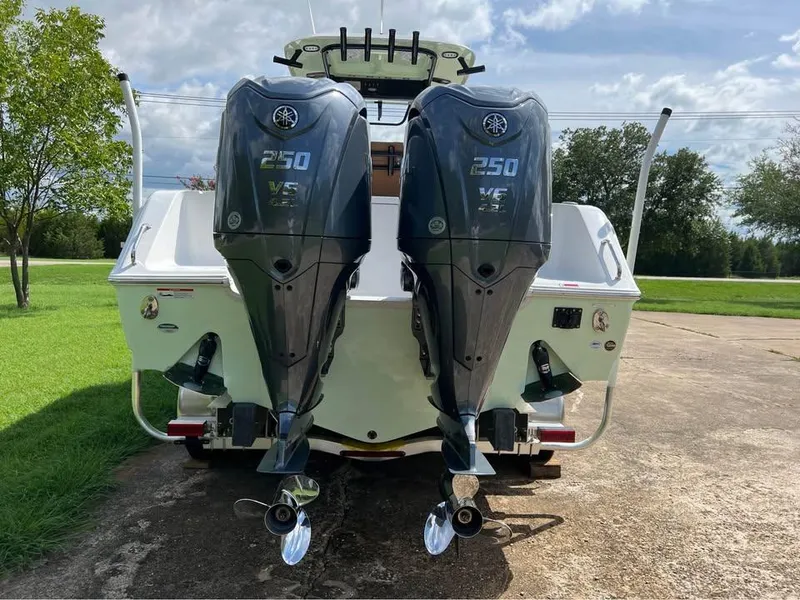 Slide: The Image of 2022 Sea Hunt Gamefish 27 with dual Yamaha 250 engines, parked outdoors. - 2