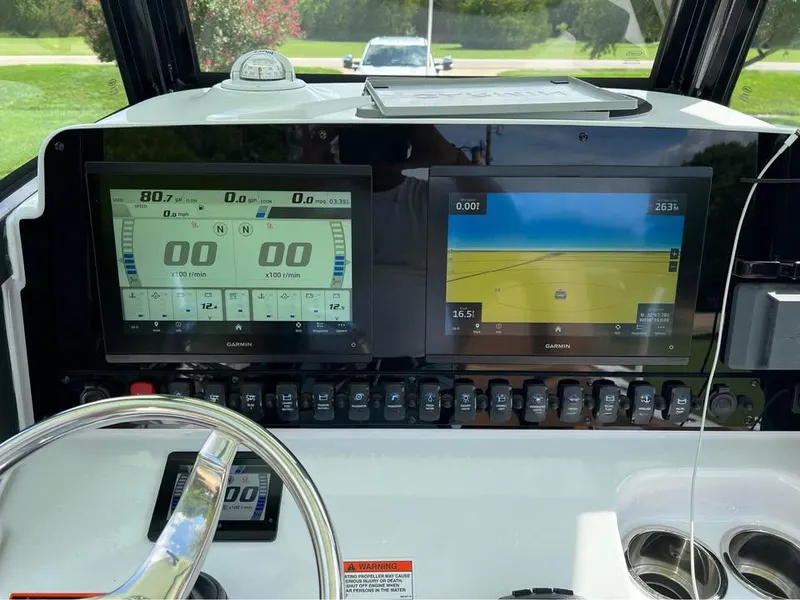 Slide: The Image of 2022 Sea Hunt Gamefish 27 dashboard with dual Garmin displays and steering wheel. - 4