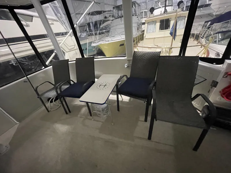 Slide: The Image of 1995 Carver 440 Aft Cabin Motor Yacht interior with chairs and table setup. - 15