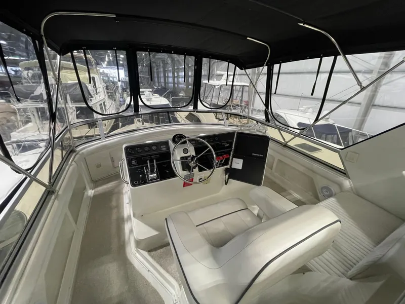 Slide: The Image of 1995 Carver 440 Aft Cabin Motor Yacht helm with steering wheel and controls. - 16