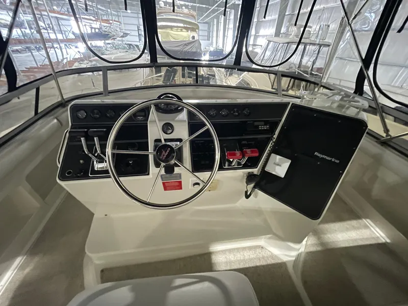 Slide: The Image of 1995 Carver 440 Aft Cabin Motor Yacht helm with steering wheel and control panel. - 17