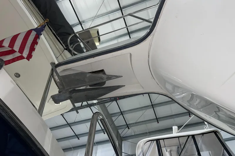 Slide: The Image of 1995 Carver 440 Aft Cabin Motor Yacht anchor and American flag in a marina. - 2