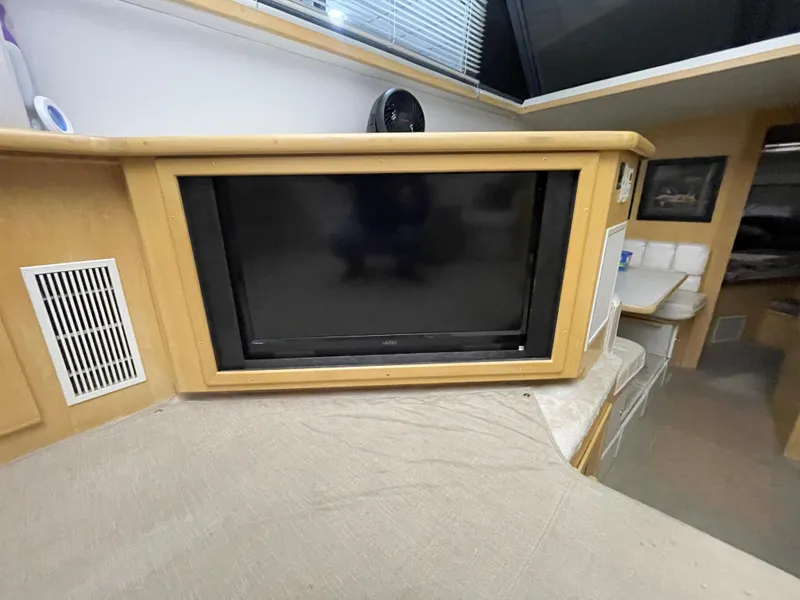 Slide: The Image of 1995 Carver 440 Aft Cabin Motor Yacht interior with built-in TV and cozy seating area. - 27