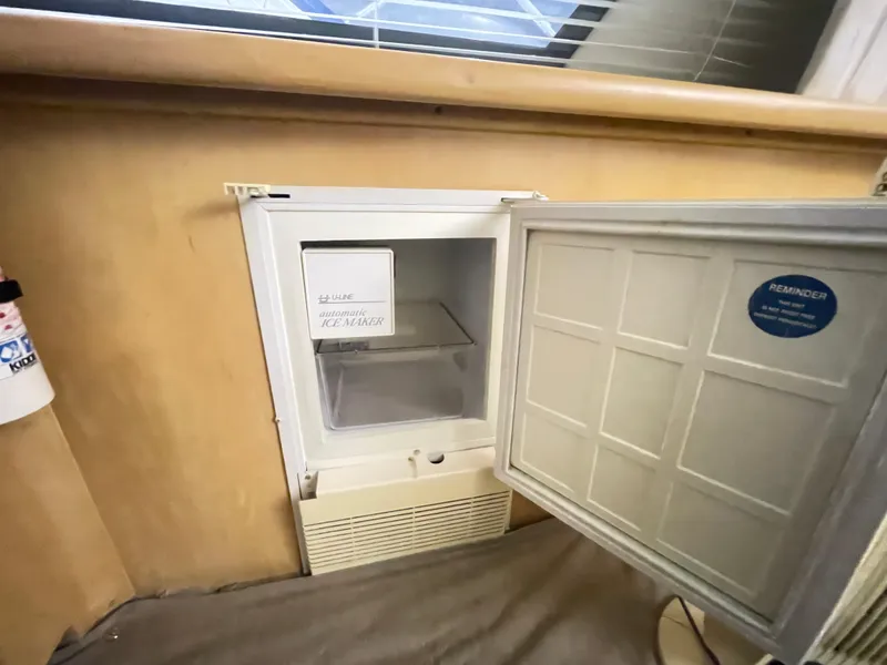 Slide: The Image of 1995 Carver 440 Aft Cabin Motor Yacht interior with open mini fridge. - 30