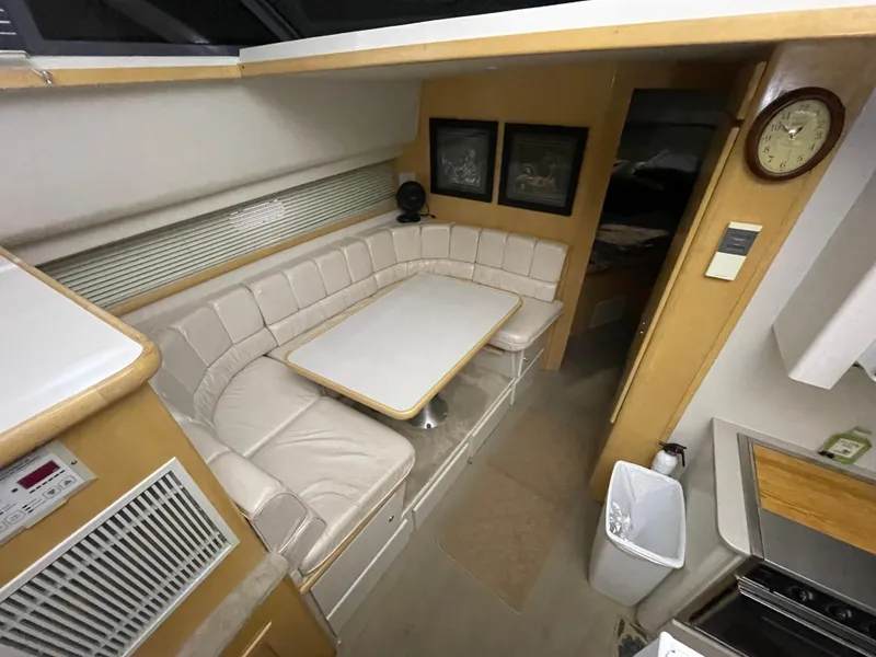 Slide: The Image of 1995 Carver 440 Aft Cabin Motor Yacht interior with cozy dining area and beige seating. - 33