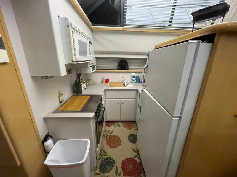 Slide: The Image of Compact kitchen in a 1995 Carver 440 Aft Cabin Motor Yacht, featuring modern appliances. - 35